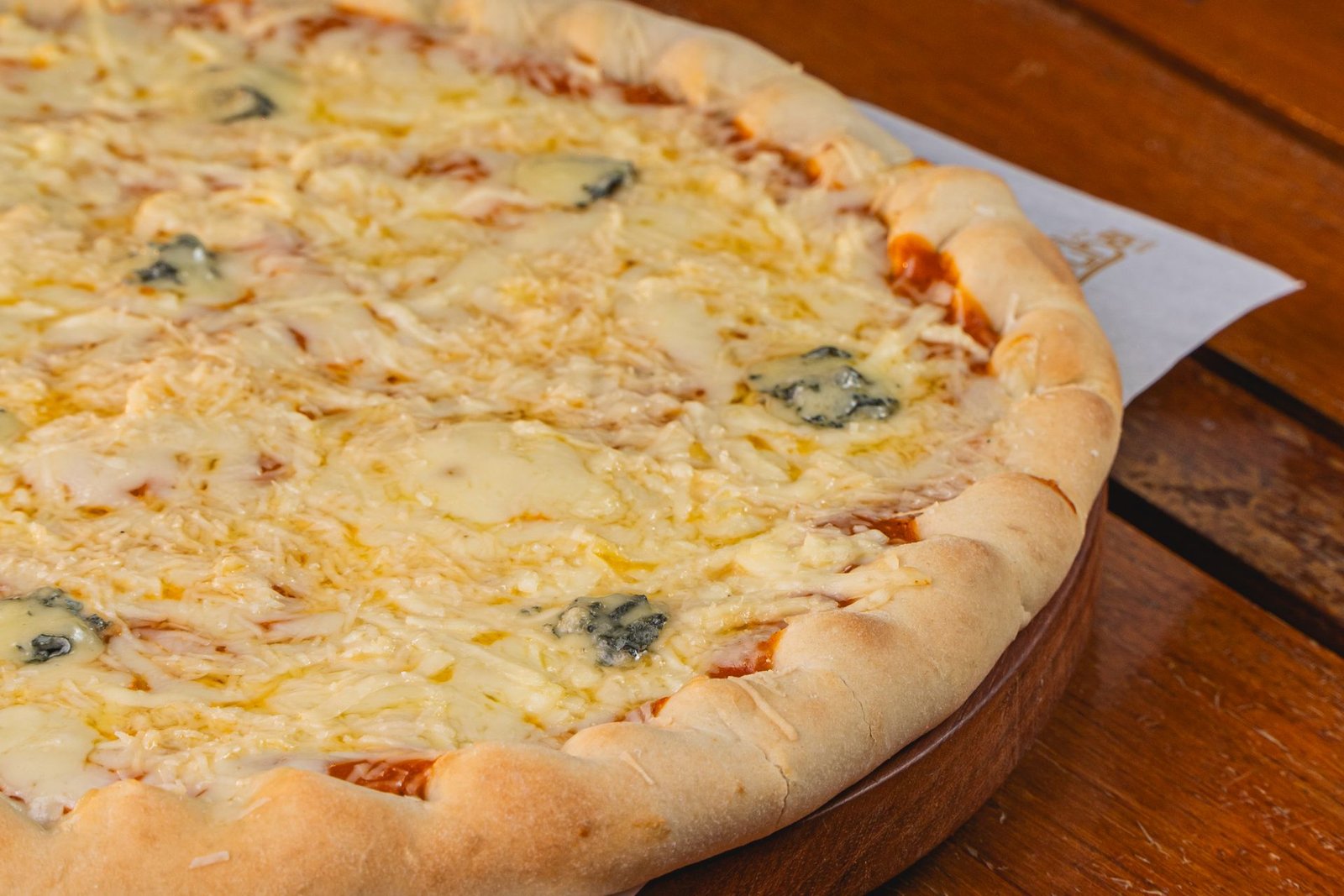 Close-up of Delicious Four Cheese Pizza on Wooden Table