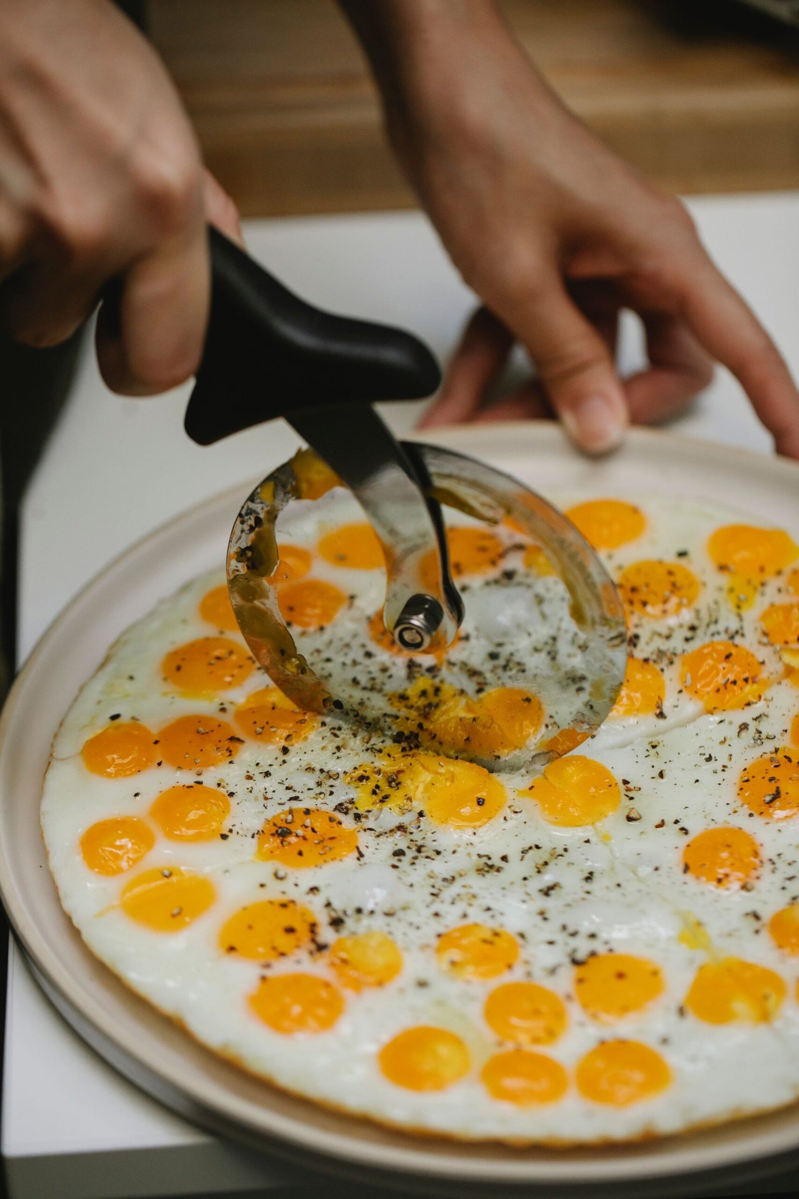 Crop unrecognizable chef cutting fried quail eggs