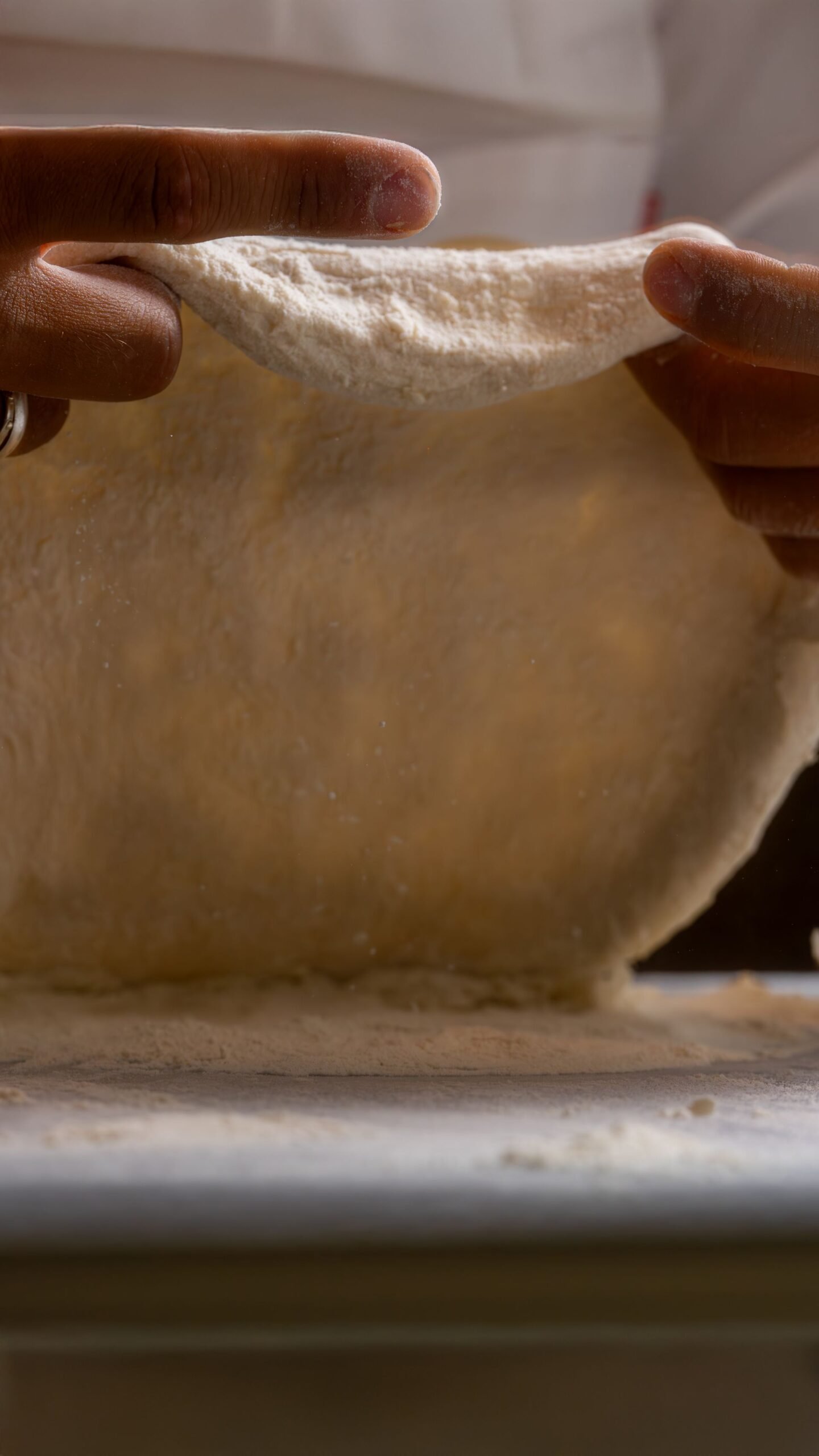 Close-up of Hands Stretching Pizza Dough