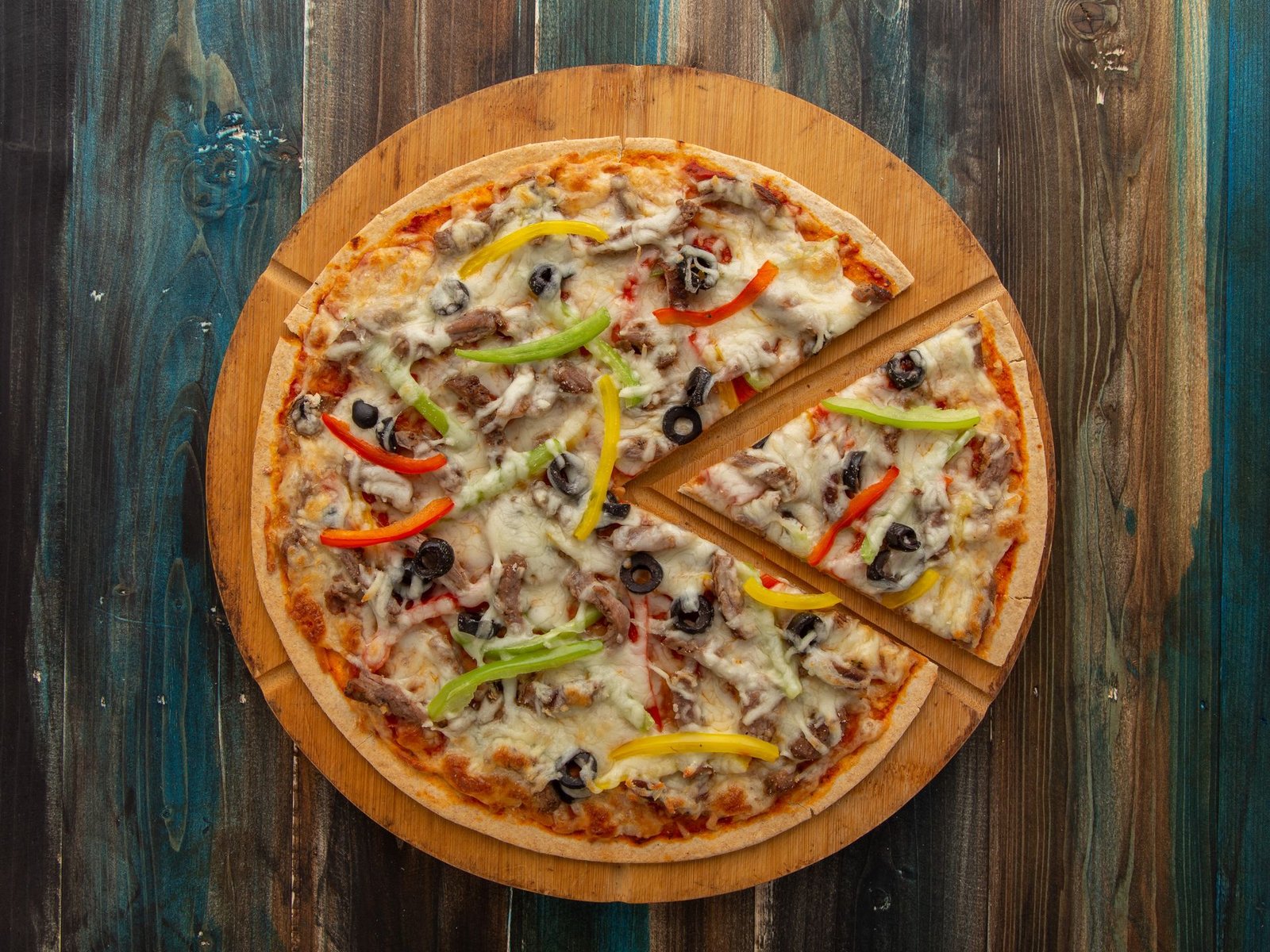Top View of a Pizza on a Wooden Cutting Board 