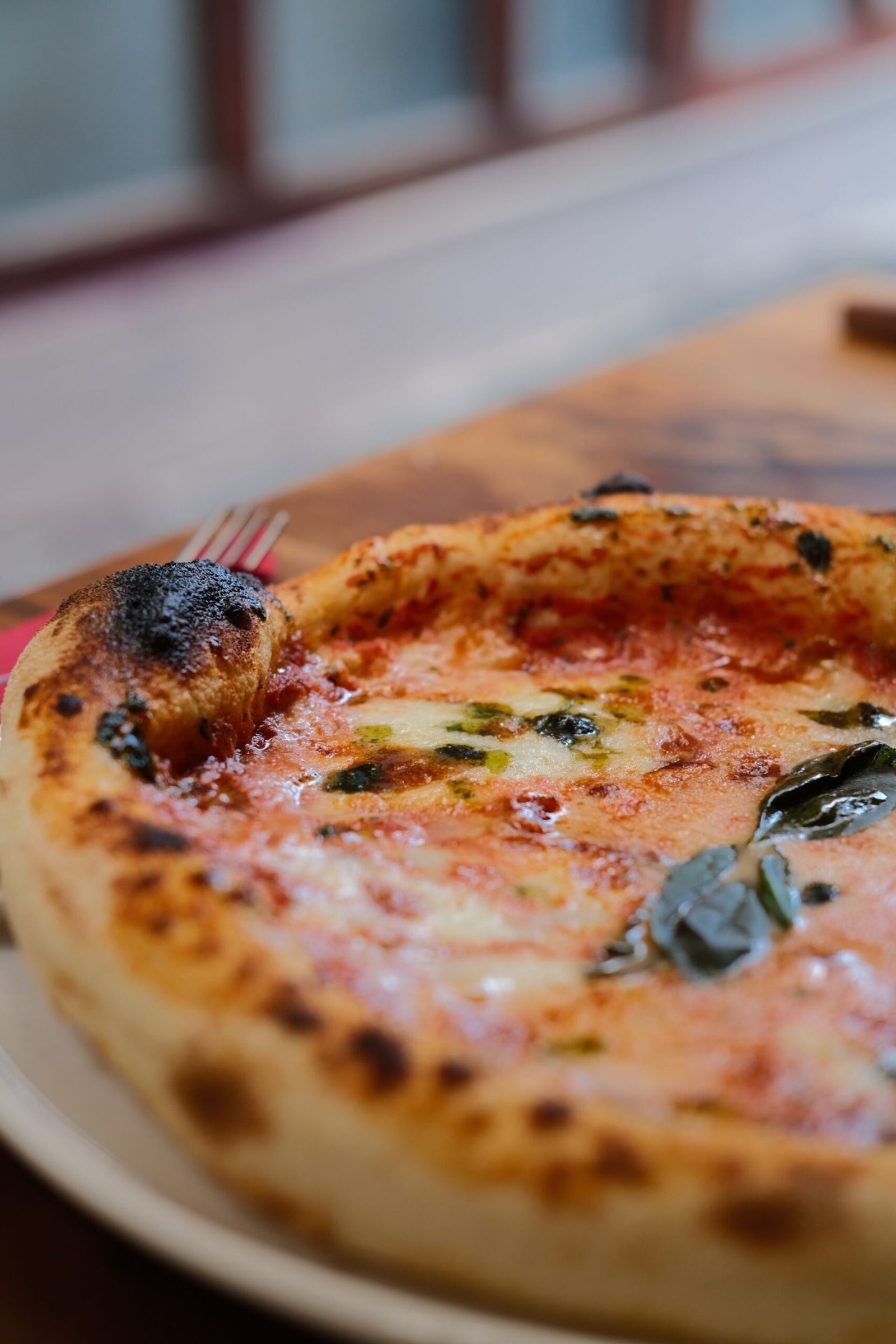 A pizza with cheese and basil on it