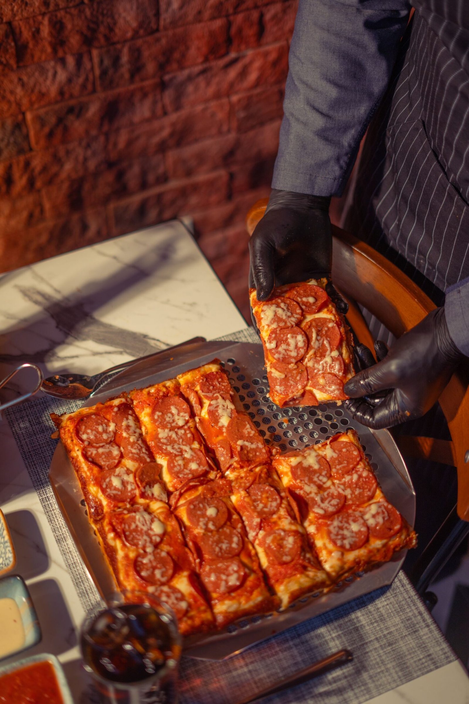 Chef Serving Slices of Pepperoni Pizza