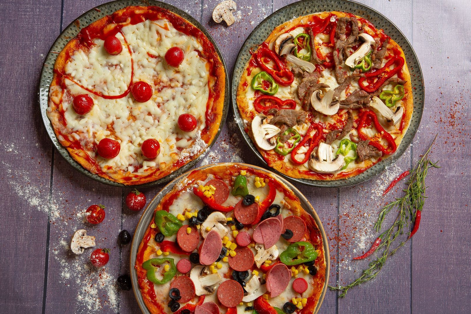 Delicious Variety of Gourmet Pizzas on Rustic Table