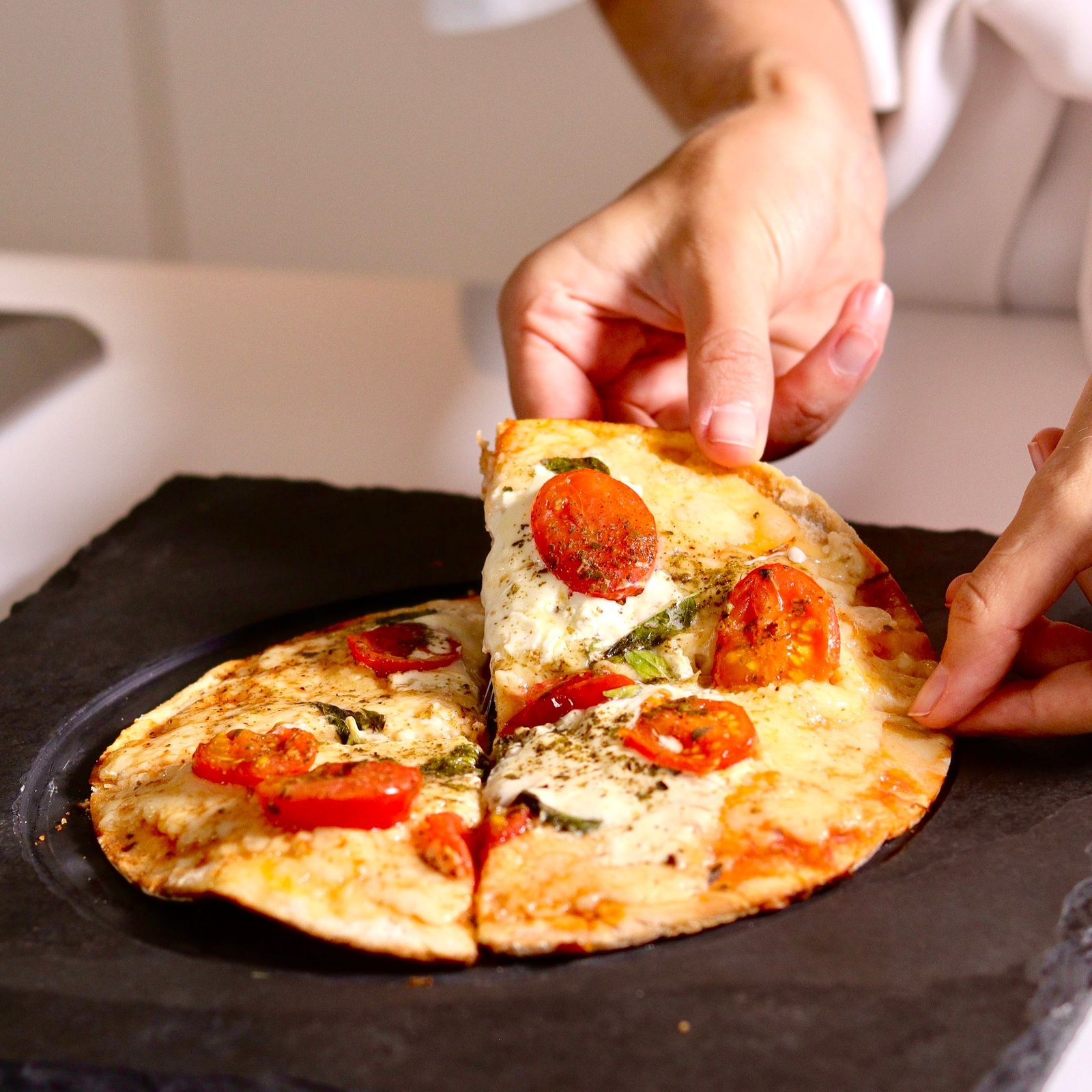 Close-Up Shot of a Person Holding a Slice of Pizza