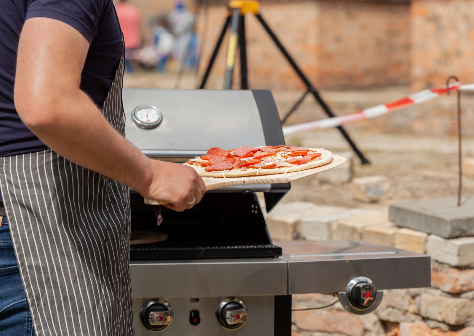 A Person Putting Pizza in the Oven