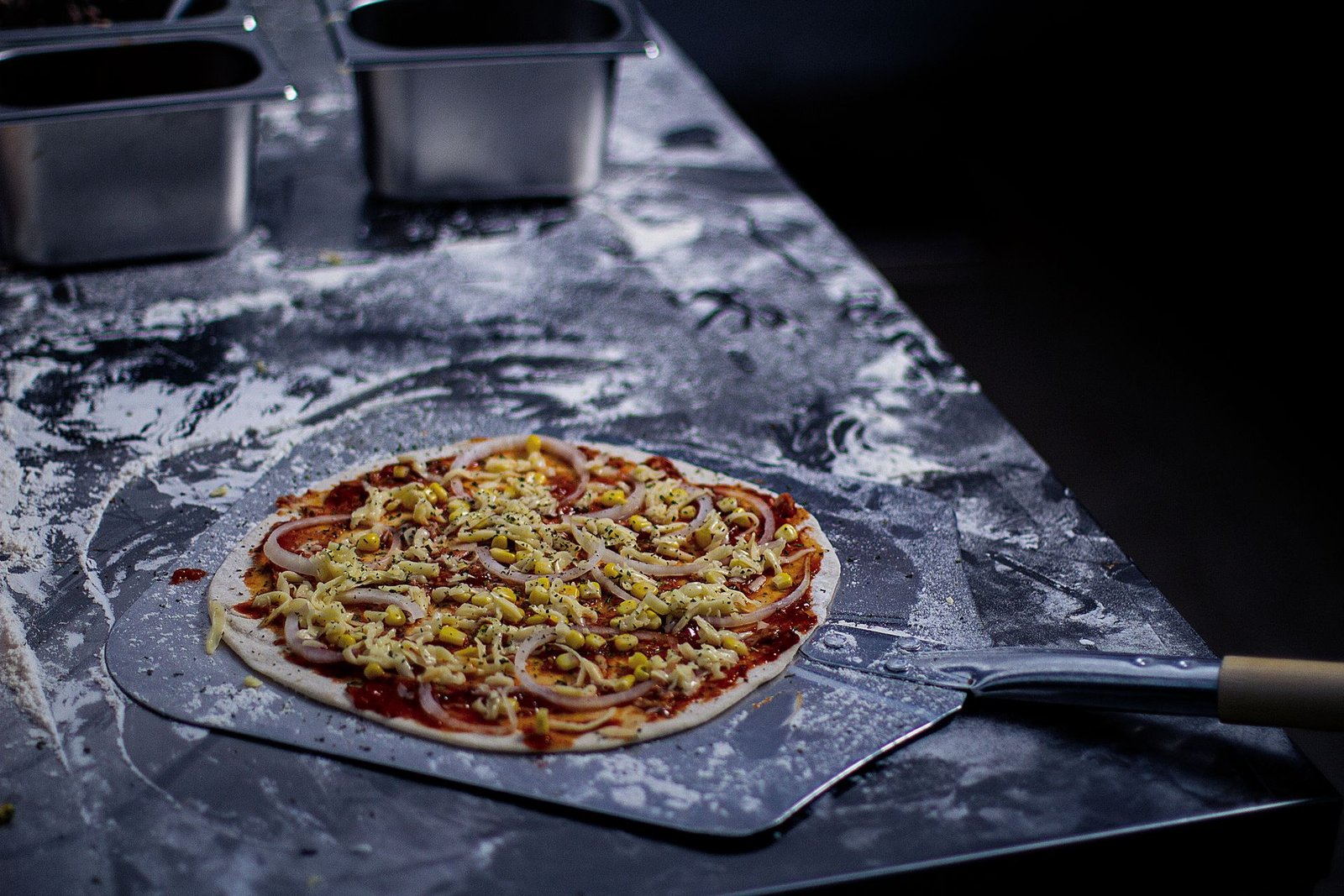 Fresh Pizza Dough with Toppings on Baking Peel