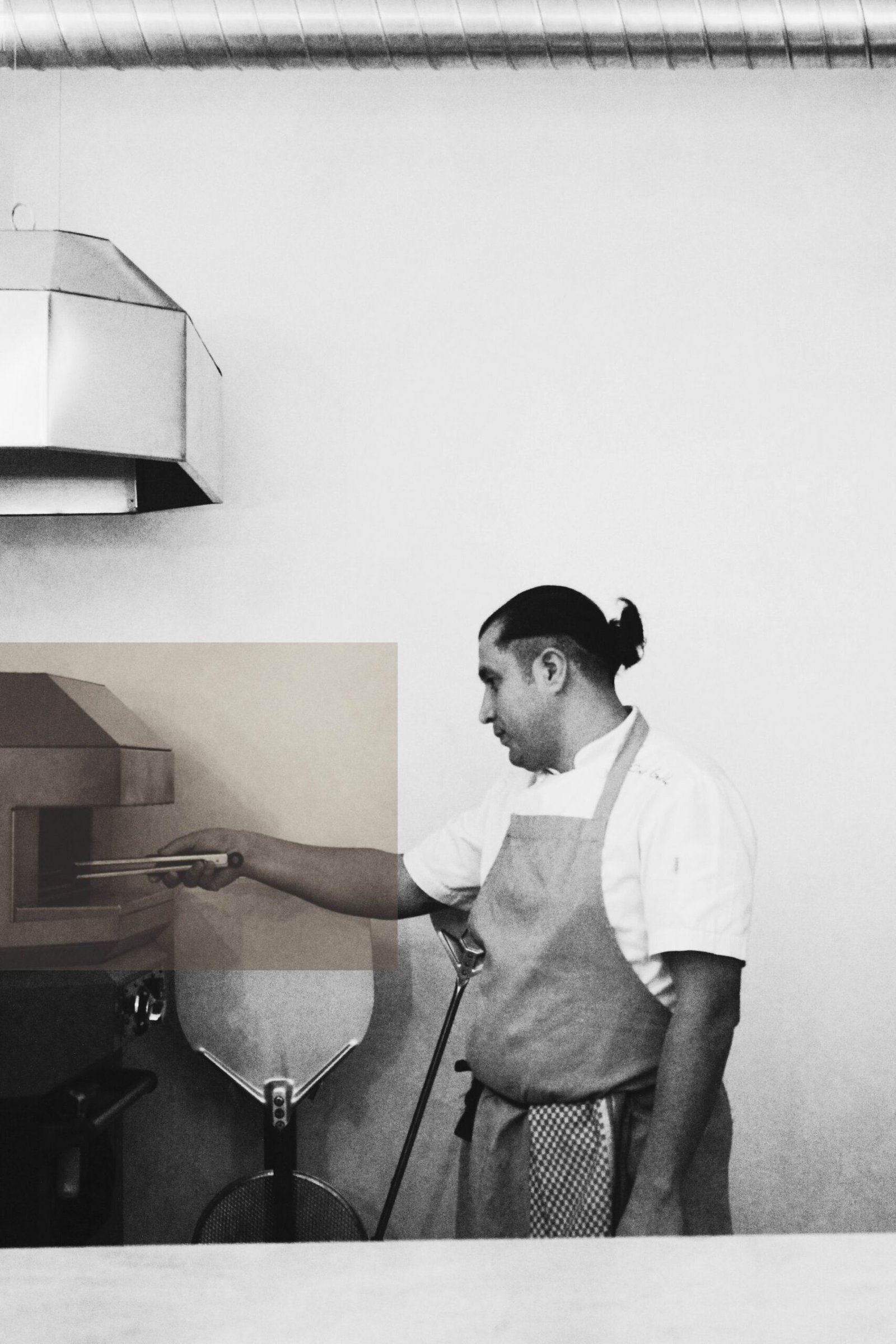 Chef working with pizza oven in modern kitchen