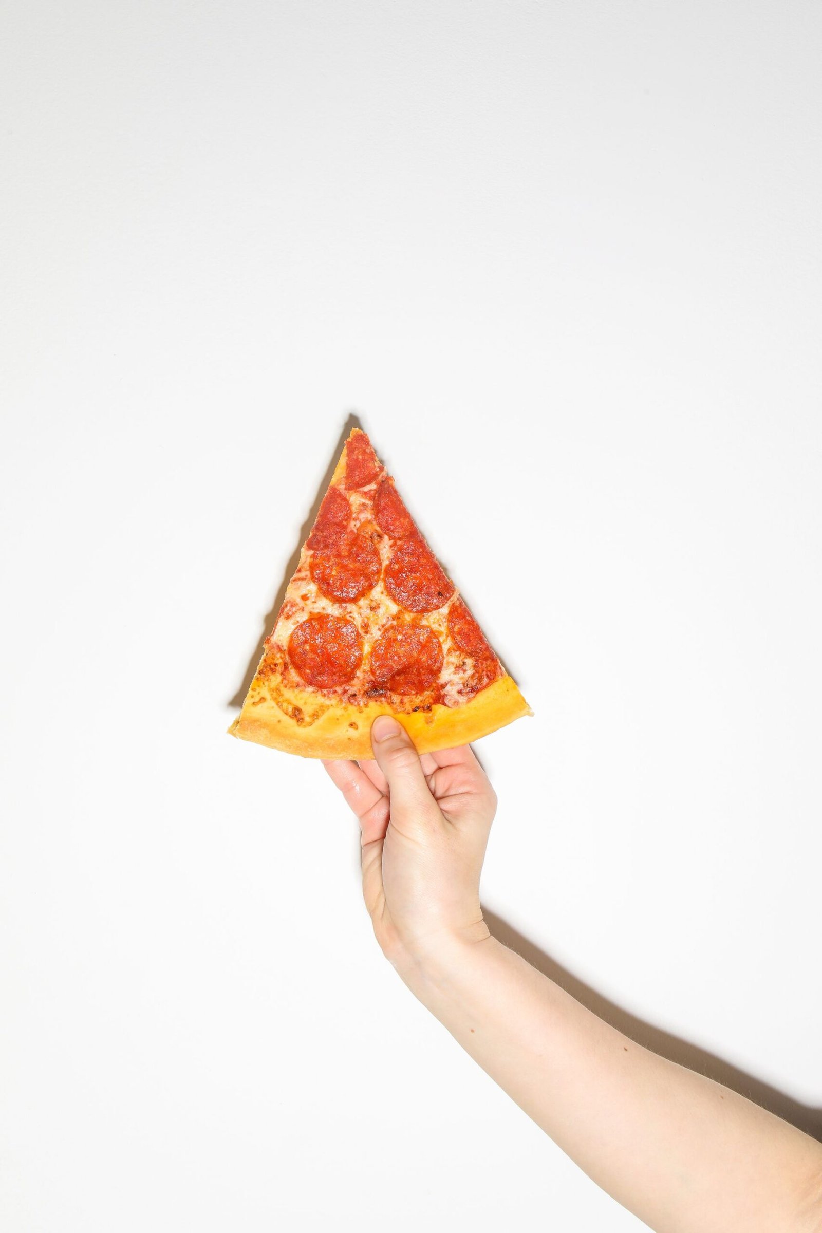 A Person Holding a Slice of Pizza