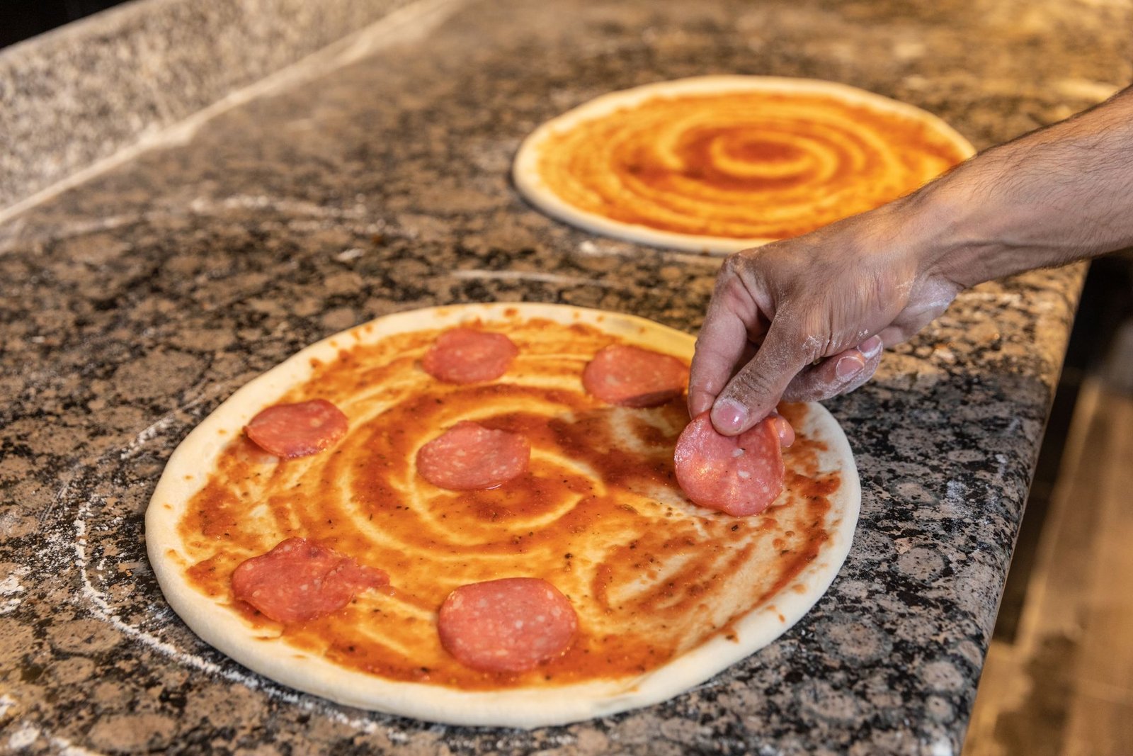 A Person Preparing Pepperoni Pizza 