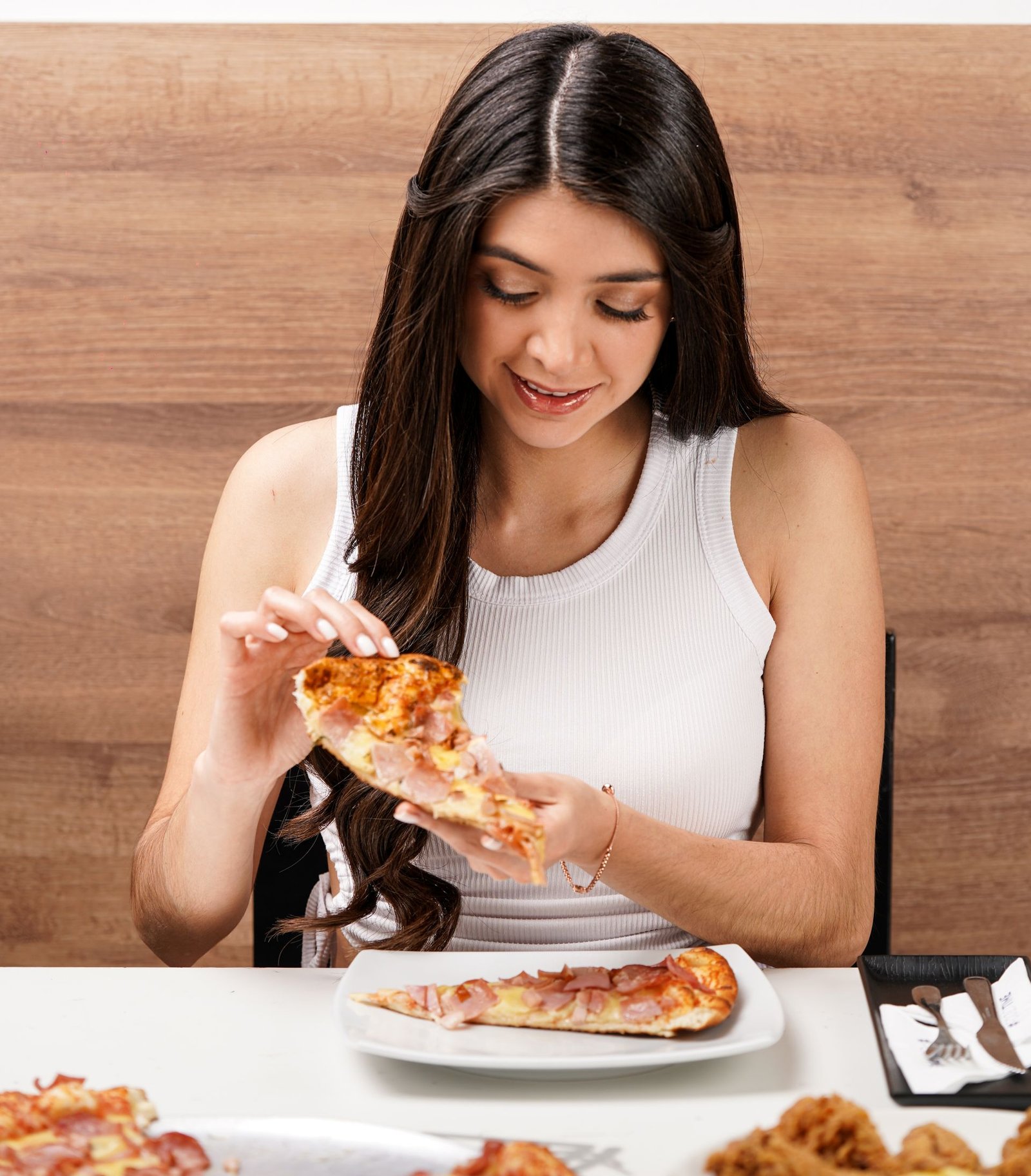 Woman Enjoying Pizza Slice in Casual Setting