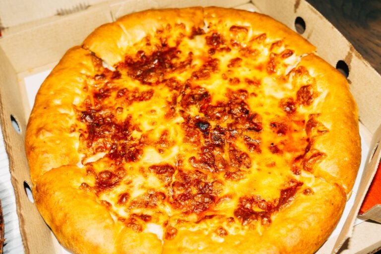 A pizza in a box with cheese on it
