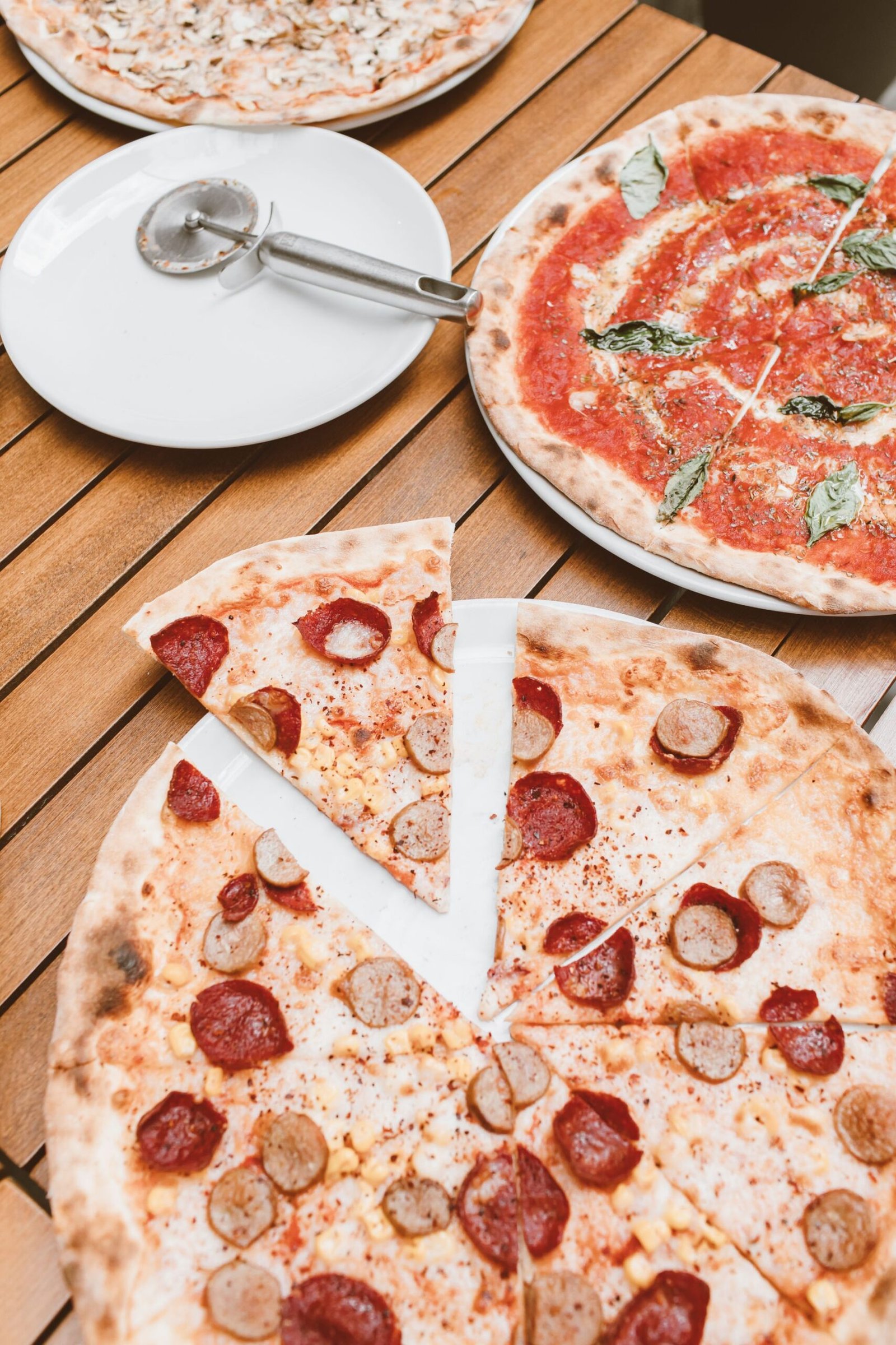 Different Flavor of Pizzas on a Wooden Surface