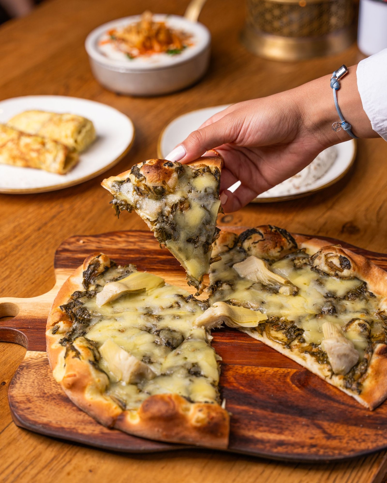 Hand Holding a Piece of Pizza