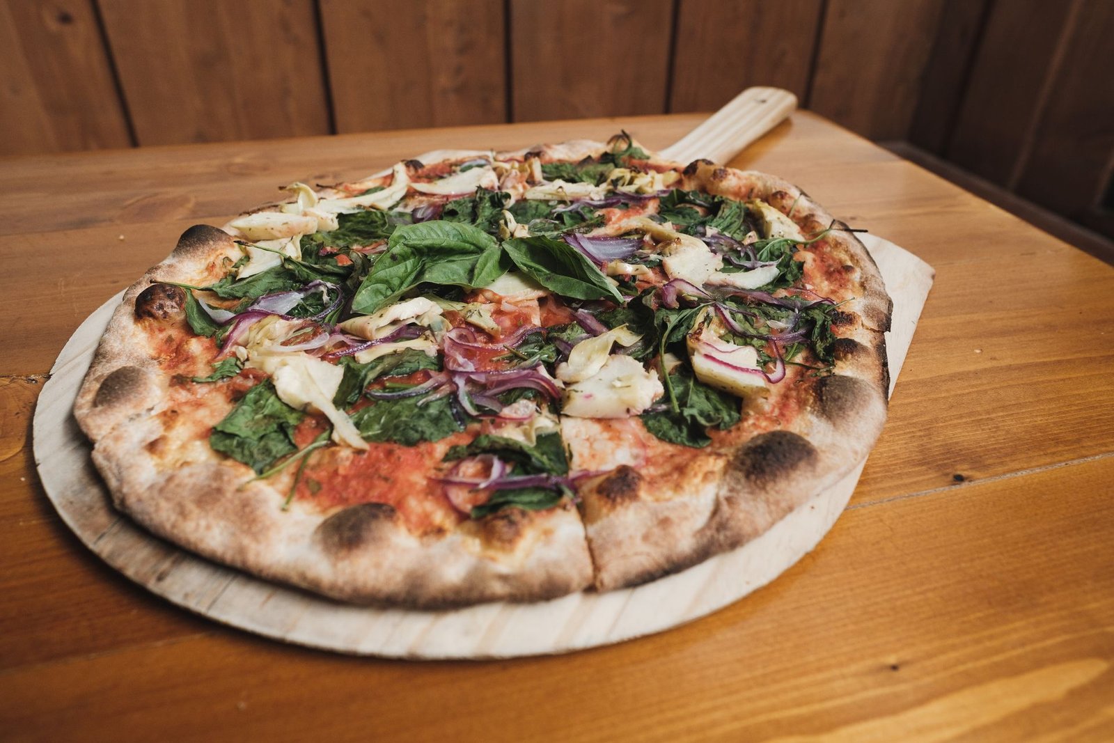 Pizza With Green Leaves on Brown Wooden Table