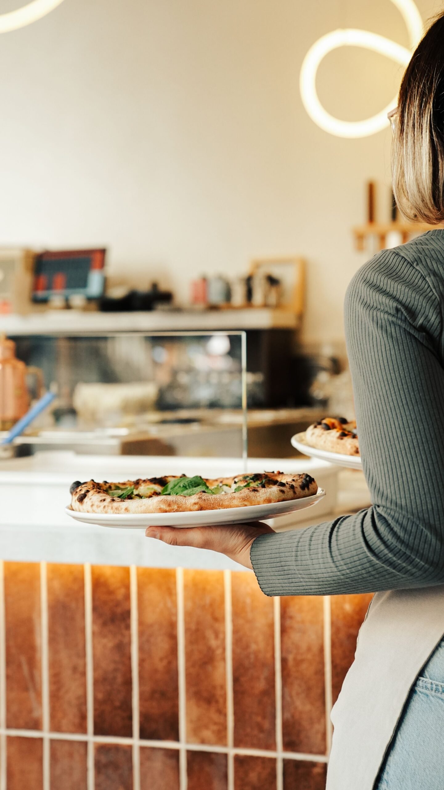 Waitress Serving Fresh Pizza in Cozy Restaurant
