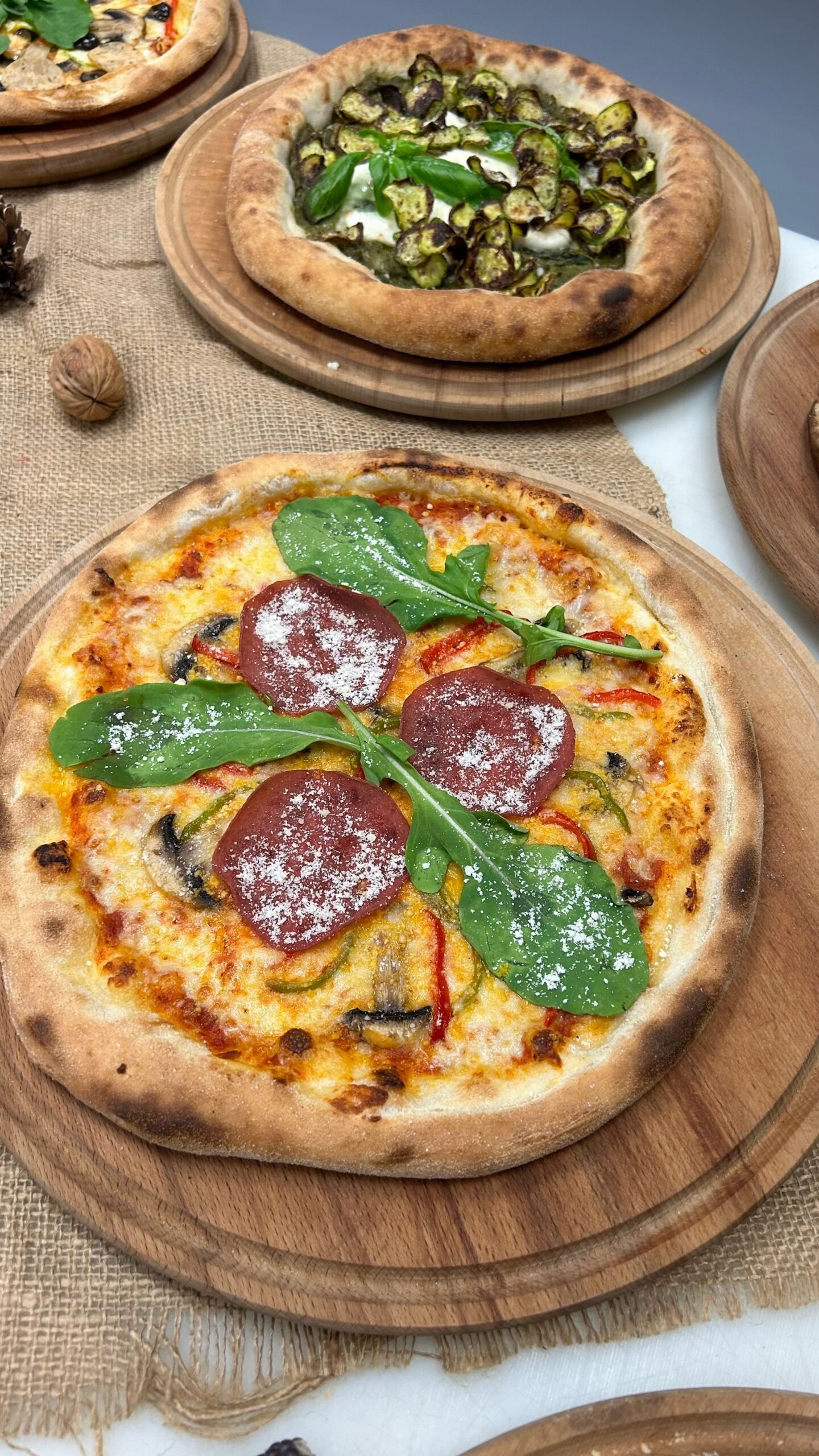 Pizza with Salami Mushrooms Peppers and Arugula in a Restaurant